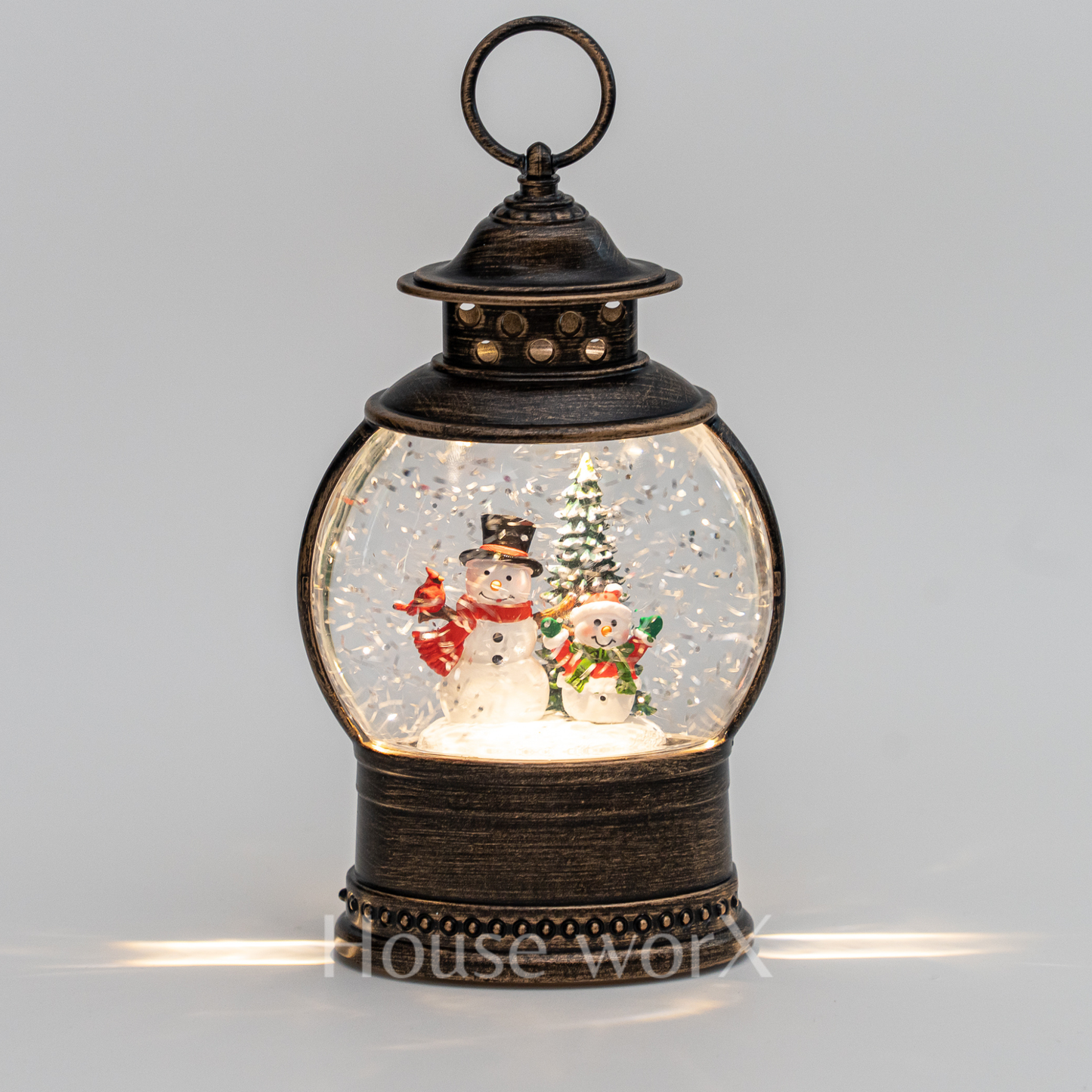 Decorative lantern with snowmen and a Christmas tree inside on a gray background