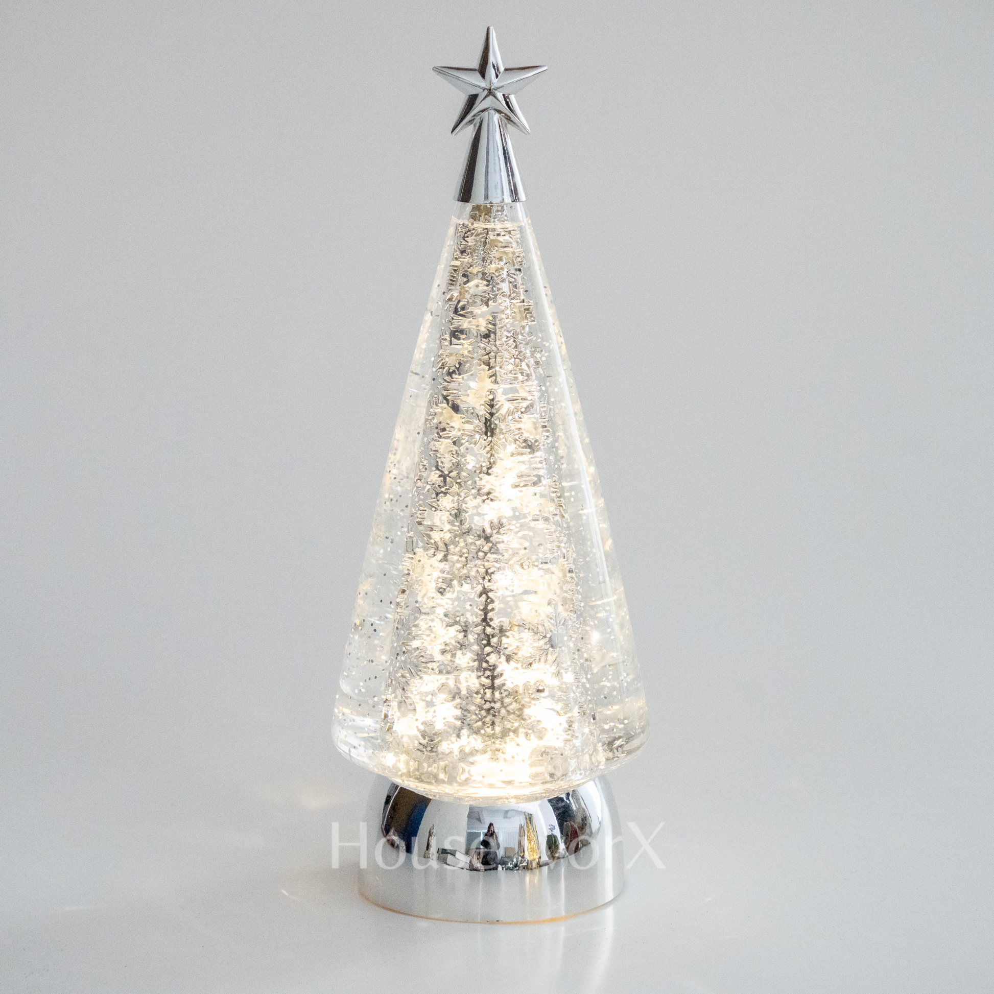 Decorative Christmas tree with a star on top against a gray background snow globe